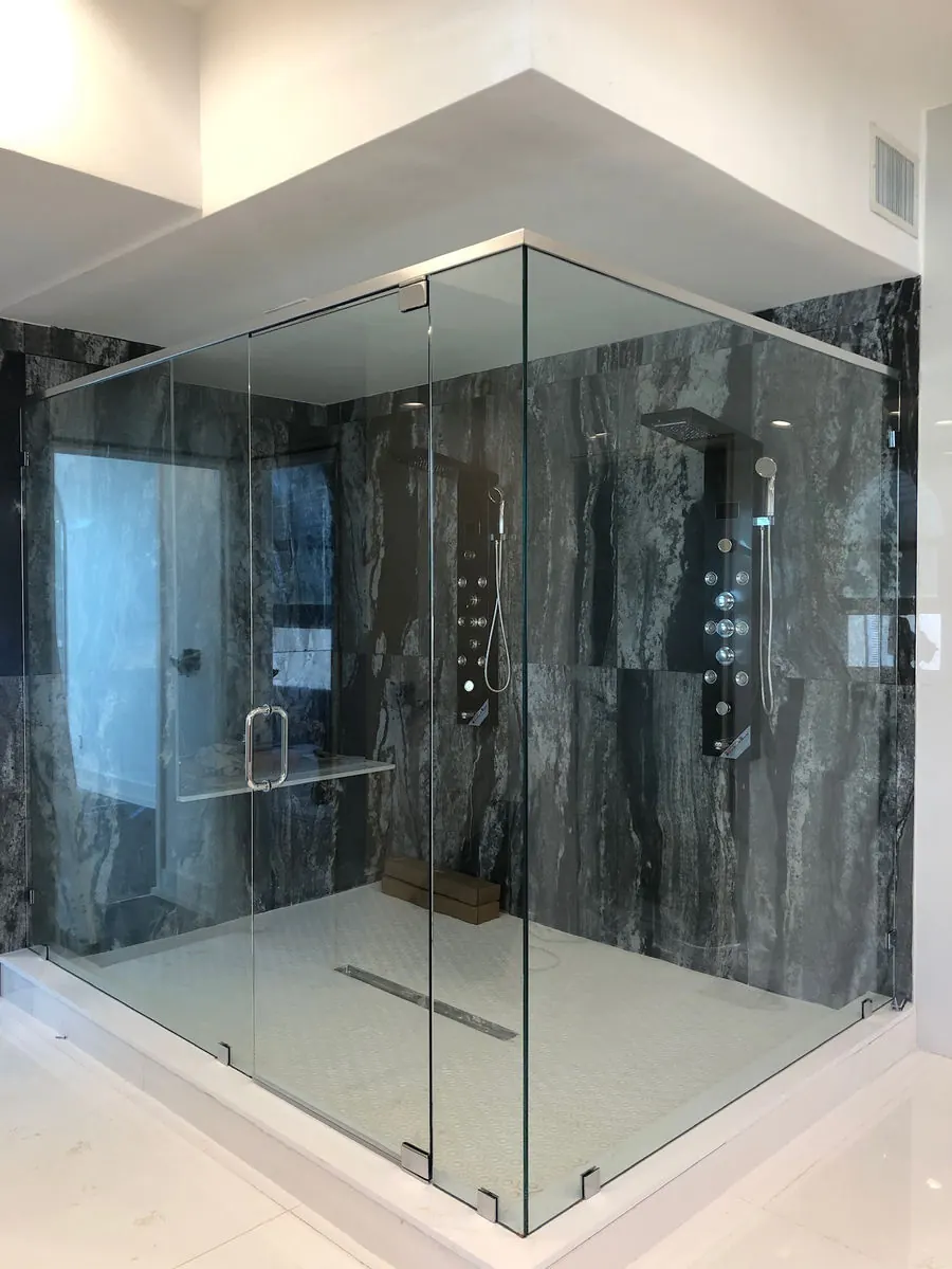 Remodeled bathroom with a frameless glass walk-in shower and dark marble-look tile walls
